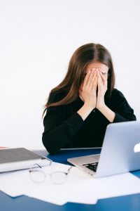 Woman feeling overwhelmed and stressed covering her face