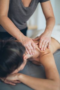 Massage therapist performs massage on client